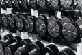 Stand with black steel dumbbells in the gym, fitness center. Concept of sports equipment and tools. Concept of sports and healthy Royalty Free Stock Photo