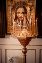 Stand with candles in front of a large icon in the church