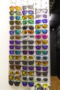 A stand of colorful various sunglasses, red, yellow, green and blue. Vertical