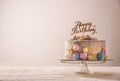 Stand with delicious birthday cake on table against light background Royalty Free Stock Photo