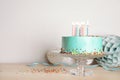 Stand with fresh delicious cake and birthday decorations on table. Royalty Free Stock Photo