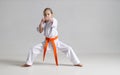 Stand in karate, a girl in a kimono strikes, on a white background Royalty Free Stock Photo