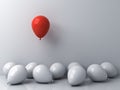 Stand out from the crowd and different concepts One red balloon floating above other white balloons on white wall background