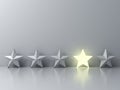 Stand out from the crowd and different creative idea concepts , One glowing star standing among other dim stars on grey background Royalty Free Stock Photo