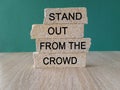 Stand out from the crowd symbol. Concept words Stand out from the crowd on brick blocks