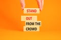 Stand out from the crowd symbol. Concept words Stand out from the crowd on wooden blocks on beautiful orange table orange