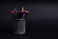 Stand for pens and pencils on the desktop on a black background with copy space. Close-up of a metal bucket with stationery. Royalty Free Stock Photo