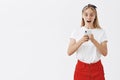 Stand still you gonna be shocked. Portrait of surprised and excited speechless girl with fair hair in skirt and headband