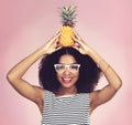 Stand tall and be sweet. Studio shot of a beautiful young woman posing with a pineapple on her head. Royalty Free Stock Photo