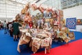 A stand with tapestries and embroidered items in the exhibition hall at the popular traditional urban fair of handicrafts.