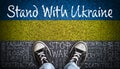 Stand With Ukraine Message on Asphalt With Painted Flag and Stop War Word Cloud Royalty Free Stock Photo