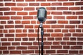 stand-up comedy microphone with a detailed brick wall behind