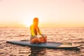 Stand up paddle boarding on a quiet sea with sunset colors. Woman relax on sup board Royalty Free Stock Photo