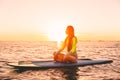 Stand up paddle boarding on a quiet sea with warm sunset colors. Relaxing on ocean Royalty Free Stock Photo