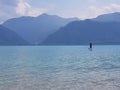 Stand up paddler on a clear blue moutain lake in Austria