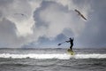 a stand up paddler surfing on an ocean wave