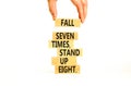 Stand up symbol. Concept words Fall seven times stand up eight on wooden blocks. Beautiful white table white background.