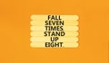 Stand up symbol. Concept words Fall seven times stand up eight on wooden stick. Beautiful orange table orange background. Business