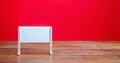 Stand or white board on a red background. Empty whiteboard. Minimalism. Business process concept, strategy planning at meetings