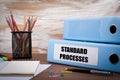 Standard Processes, Office Binder on Wooden Desk. On the table c Royalty Free Stock Photo