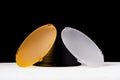 Standard reflector with matt white and yellow diffuser on a black background. Different diffusers for light temperatures. Royalty Free Stock Photo