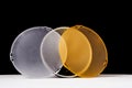 Standard reflector with matt white and yellow diffuser on a black background. Different diffusers for light temperatures. Royalty Free Stock Photo