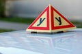 Standard triangle piramid sign of a russian driving school on top of the vehicle.