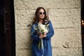 In blue clothes. Beautiful woman is with flowers in hands outdoors Royalty Free Stock Photo