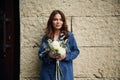 In blue clothes. Beautiful woman is with flowers in hands outdoors Royalty Free Stock Photo