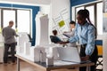 Standing architect with laptop looking at scale foam model