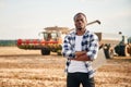 Standing with arms crossed. Beautiful African American man is in the agricultural field Royalty Free Stock Photo