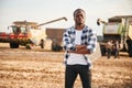 Standing with arms crossed. Beautiful African American man is in the agricultural field Royalty Free Stock Photo