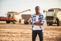 Standing with arms crossed. Beautiful African American man is in the agricultural field Royalty Free Stock Photo