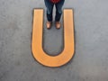 Conceptual image of person standing on asphalt concrete in front of U-Turn symbol, generative Ai