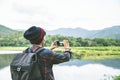 Standing back the Asian man using Camera smartphone Selfie taken of yourself connected to digital camera shooting photo Mountain