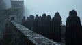 Standing on a balcony a group of hooded figures face away from the camera voices echoing off the stone walls as they