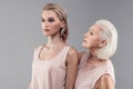 Caring senior grey-haired woman refreshing bob hairstyle of her daughter