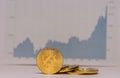 standing bitcoins net to each other with a unsharp fluctuating stock market chart in the background middle Royalty Free Stock Photo