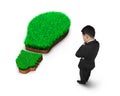 Standing businessman pondering over green grass of light bulb Royalty Free Stock Photo