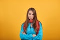 Standing and cross her arms on chest. Young attractive woman with brown hair