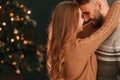 Standing and embracing. Lovely young couple are celebrating New Year at home