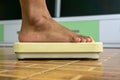 Standing on floor scale. Close up of man legs stapping on weight scales