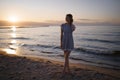 Standing full height: Portrait of a Beautiful blonde woman in a light blue dress on the Baltic Sea beach during sunset Royalty Free Stock Photo