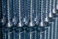Standing galvanized self-tapping screws on a mirror surface