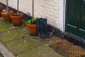 Standing high waders with beautiful brown pots at the entrance t