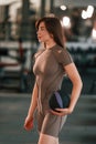 Standing and holding fitness ball. Beautiful woman with sport body type is in the gym Royalty Free Stock Photo