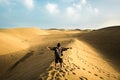 Standing man back view open arms and enjoy with wild beautiful desert in front - lifestyle and adventure trekking backpack travel