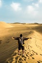 Standing man back view open arms and enjoy with wild beautiful desert in front - lifestyle and adventure trekking backpack travel