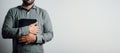 Standing man holding and hugging the bible on his chest Royalty Free Stock Photo