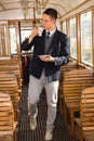 standing man with mustache and glasses on train wooden wagon drinking coffee or tea from cup and looking through window Royalty Free Stock Photo